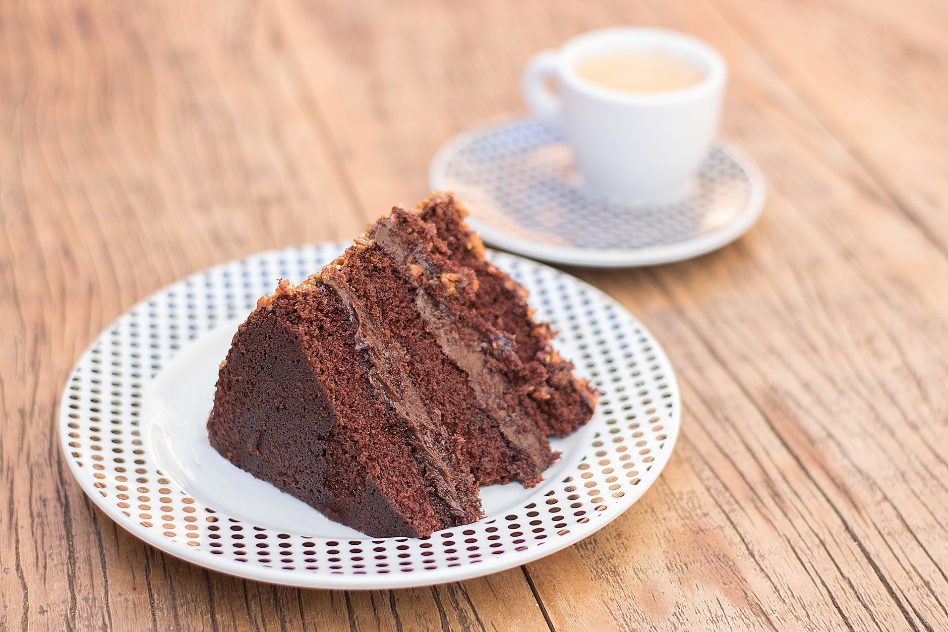 Trozo de queque de chocolate acompañado de un café