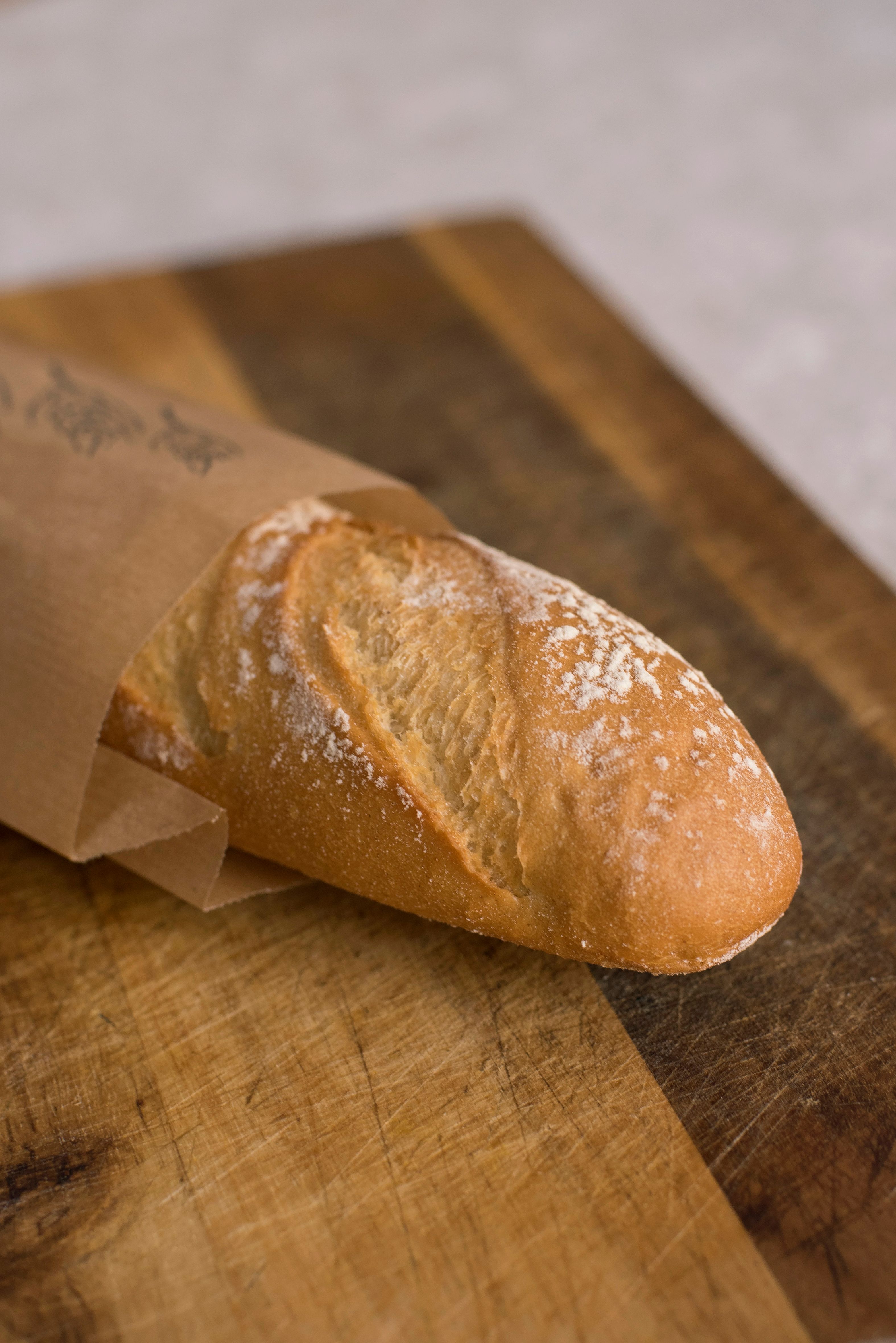 Pan de masa madre recién horneado envuelto en papel artesanal